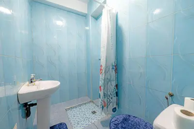 a blue tiled bathroom with a sink and a shower at Dar N3 in Marrakech