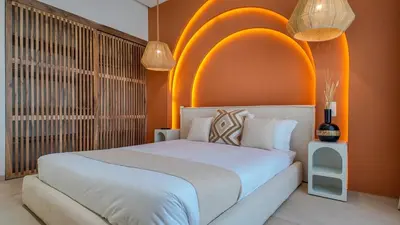 a bedroom with a white bed and an orange wall at Villa Maréa heated pool not overlooked in Marrakech