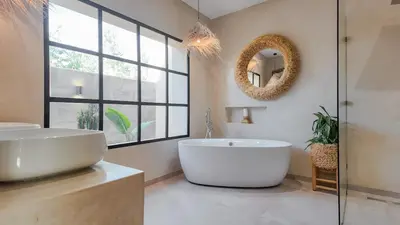 a bathroom with a large white tub and a mirror at Villa Maréa heated pool not overlooked in Marrakech