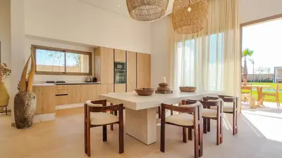 a kitchen with a island with chairs and a table at Villa Maréa heated pool not overlooked in Marrakech