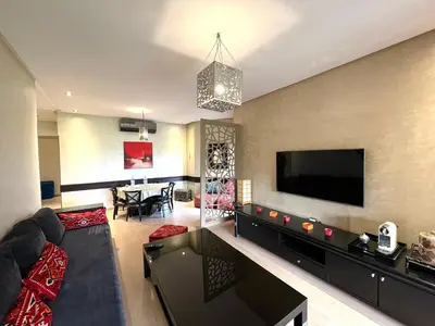 a living room with a couch and a flat screen tv at Golf Prestigia Marrakech in Marrakech