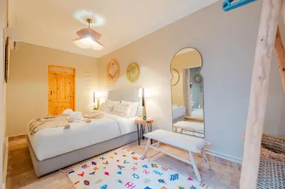a bedroom with a bed and a chair and a mirror at Riad Bahia Burgos - Exclusive - Heated Pool & Breakfast - 15 min walk Jemaa El Fnaa in Marrakech
