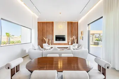 a living room with a wooden table and white chairs at Heated Pool Absolute Luxury in Marrakech