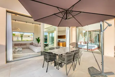 a dining room with a table and chairs and an umbrella at Heated Pool Absolute Luxury in Marrakech