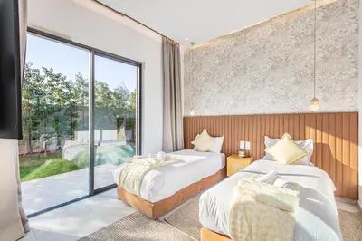 a bedroom with two beds and a large window at Heated Pool Absolute Luxury in Marrakech