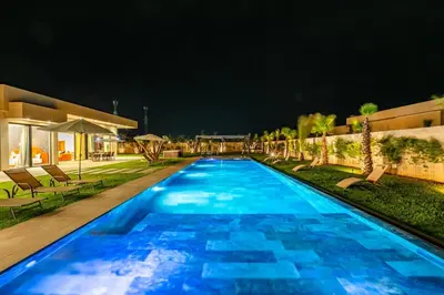 a large swimming pool with blue water at night at Prestige Villa Heated Pool Total Quiet in Marrakech