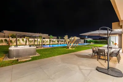 a patio with a table and an umbrella and a pool at Prestige Villa Heated Pool Total Quiet in Marrakech