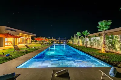 a swimming pool at night in a house at Chic Villa Jacuzzi and Green Space in Marrakech