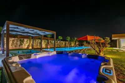 a swimming pool in a backyard at night at Chic Villa Jacuzzi and Green Space in Marrakech