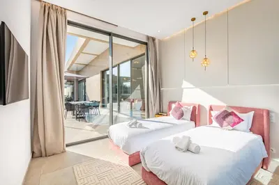 two beds in a room with a balcony at Dream Getaway Intimate Villa Private Pool in Marrakech