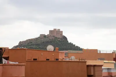 a castle on top of a hill with buildings at Stylish &cosy 1-Bedroom in Marrakech