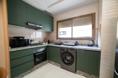 a kitchen with green cabinets and a washing machine at Stylish &cosy 1-Bedroom in Marrakech