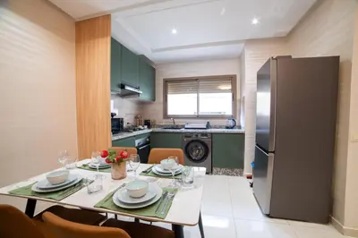 a kitchen with a dining table and a refrigerator at Stylish &cosy 1-Bedroom in Marrakech