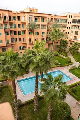 an aerial view of a building with palm trees and a swimming pool at appart hôtel in Marrakech