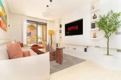 a living room with a couch and a tv on a wall at Apartment in Victor Hugo 10 minutes from Jemaa el-Fna in Marrakech
