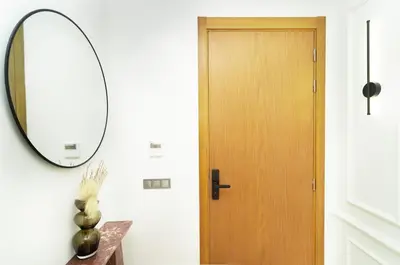a hallway with a wooden door and a mirror at Apartment in Victor Hugo 10 minutes from Jemaa el-Fna in Marrakech