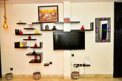 a flat screen tv on a wall with shelves at Marrakech Centre Guéliz – Calme & authentique in Marrakech