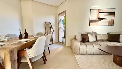 a living room with a table and a couch at Prestigia JADE Luxury and comfort Private Garden in Marrakech