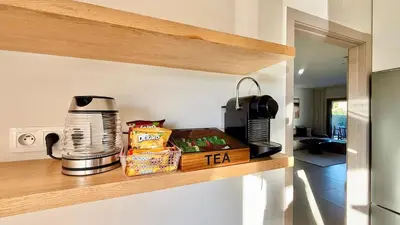 a kitchen shelf with a coffee maker and food on it at Prestigia JADE Luxury and comfort Private Garden in Marrakech