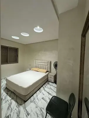 a bedroom with a bed and a table and chairs at Appartement à gueliz in Marrakech