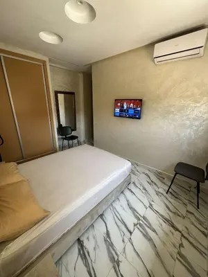 a bedroom with a bed and a tv on the wall at Appartement à gueliz in Marrakech