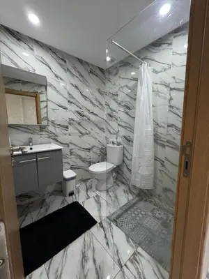 a marble bathroom with a toilet and a sink at Appartement à gueliz in Marrakech