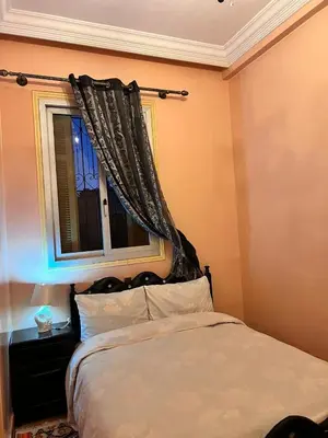 a bedroom with a bed and a window with curtains at Spacious Family Apartment near Jemaa el-Fnaa in Marrakech