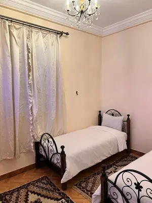 a bedroom with two beds and a chandelier at Spacious Family Apartment near Jemaa el-Fnaa in Marrakech