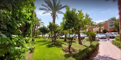 a park with palm trees and a sidewalk at Riad Ayman de luxe au centre de Marrakech Jacuzzi piscines in Marrakech