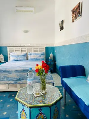 a bedroom with a bed and a vase of flowers on a table at Riad El Laadel Marrakech in Marrakech
