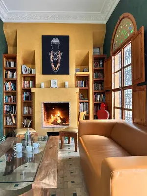 a living room with a couch and a fireplace at Riad El Laadel Marrakech in Marrakech