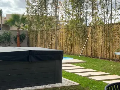 a backyard with a table and a fence at Villa Magique Piscine Chauffée Et Jacuzzi in Marrakech