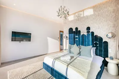a bedroom with a bed and a tv on a wall at Villa Magique Piscine Chauffée Et Jacuzzi in Marrakech