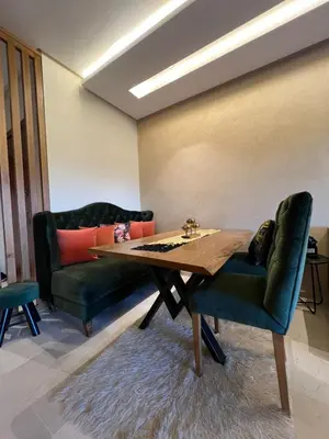 a dining room with a table and two chairs at Appart Essalam 2 in Marrakech
