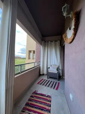 a room with a balcony with a chair and a window at Appart Essalam 2 in Marrakech