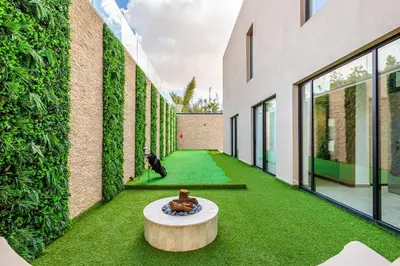 a hallway with green grass and a table in a building at Luxury villa with spa, gym and cinema 15 min from center in Marrakech