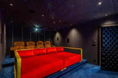 a cinema room with a red couch and chairs at Luxury villa with spa, gym and cinema 15 min from center in Marrakech