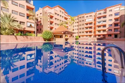 a reflection of buildings in a swimming pool at Luxe Hivernage Piscine Géante & Terrasse XXL in Marrakech