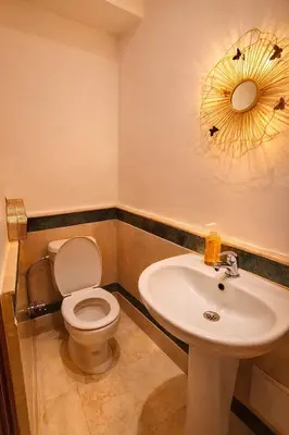 a bathroom with a sink and a toilet and a mirror at Luxe Hivernage Piscine Géante & Terrasse XXL in Marrakech