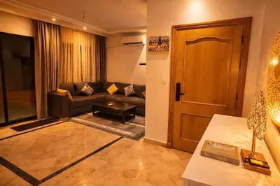 a living room with a couch and a door at Luxe Hivernage Piscine Géante & Terrasse XXL in Marrakech
