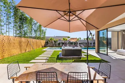 a patio with a table and chairs and an umbrella at Villa with jacuzzi in Marrakech