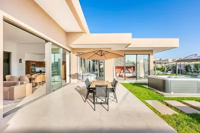 a patio with a table and chairs and an umbrella at Villa with jacuzzi in Marrakech