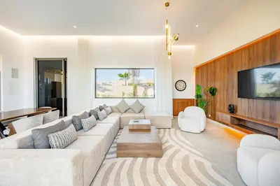 a living room with a large couch and a tv at Modern design and jacuzzi in Marrakech