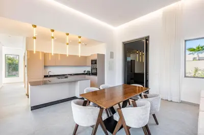 a kitchen and dining room with a wooden table and chairs at Modern design and jacuzzi in Marrakech