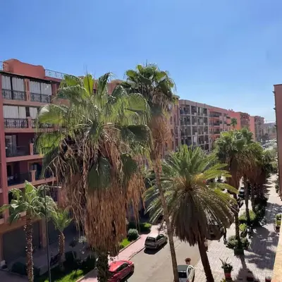 a view of a street with palm trees and buildings at Central location in Gueliz in Marrakech