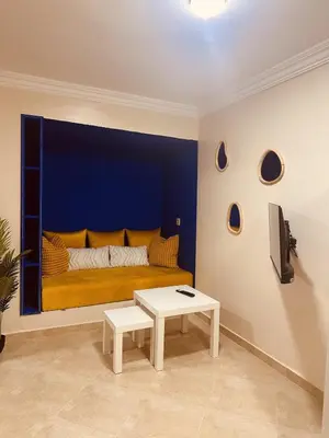 a living room with a yellow bed with a blue wall at Blue and sun Majorelle comfort and spacious in Marrakech