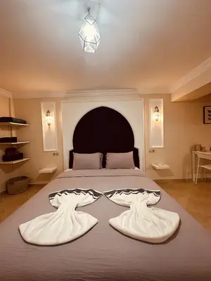 a bedroom with a large bed with a black headboard at Blue and sun Majorelle comfort and spacious in Marrakech
