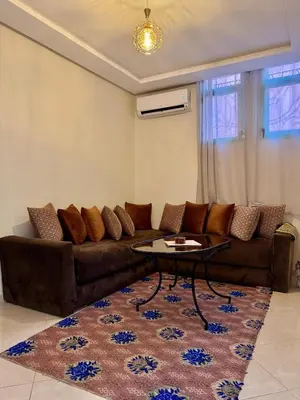 a living room with a brown couch and a table at Gouarial in Marrakech