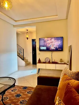a living room with a couch and a flat screen tv at Gouarial in Marrakech