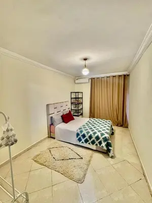 a bedroom with a bed and a window and a rug at Gouarial in Marrakech